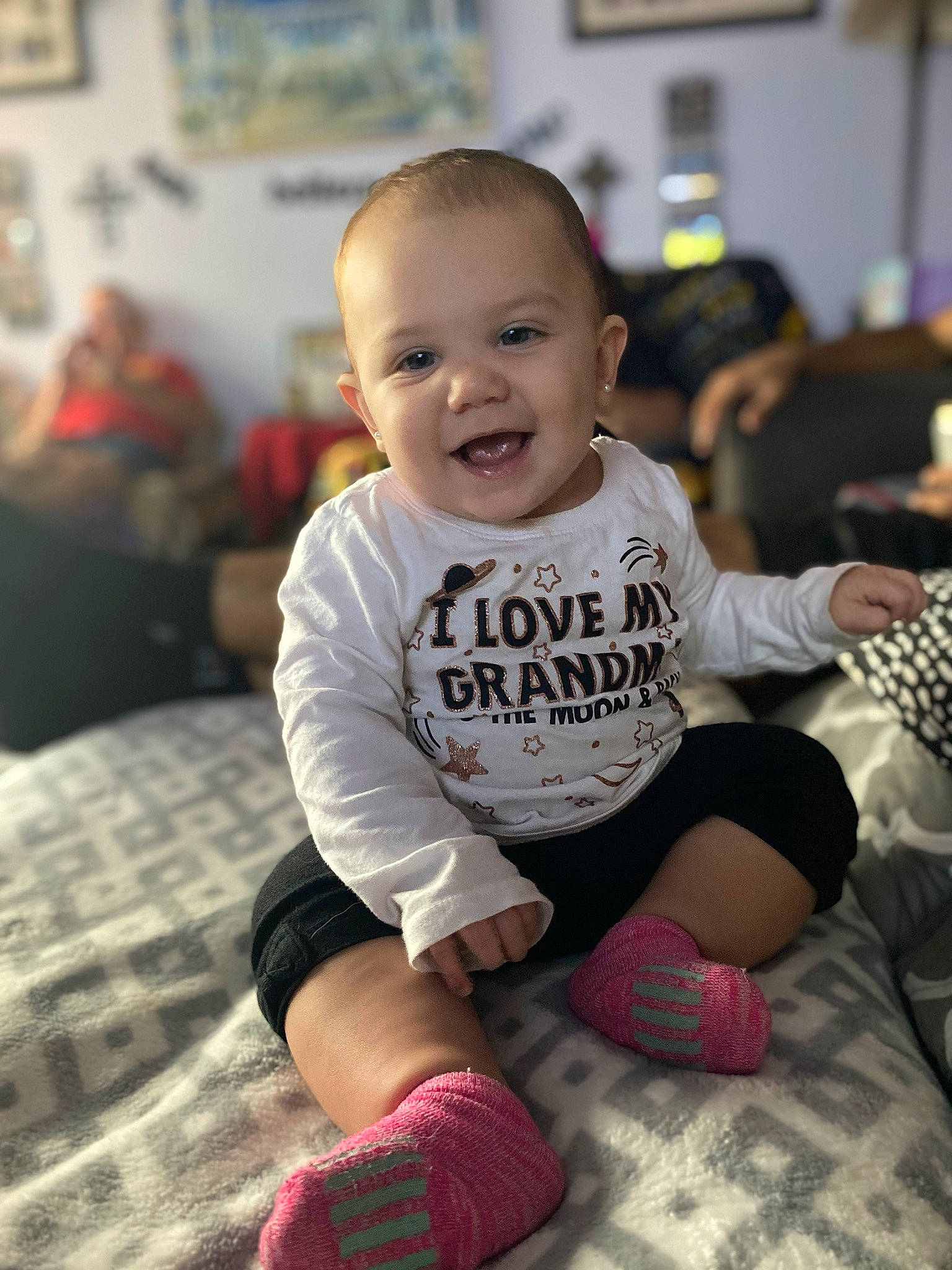 Raelyn is registered to the contest to win money with this photo: arm, baby, beauty, cheek, child, face, facial_expression, footwear, happy, head, joint, joy, leg, people, person, pink, room, sitting, skin, smile