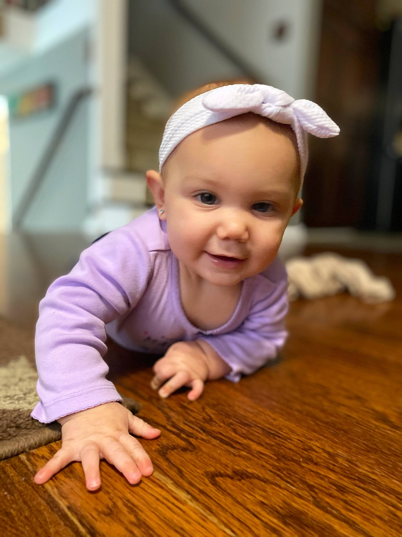 Raelyn joined the competition — help win amazing prizes! baby, cheek, child, crawling, floor, flooring, hair_accessory, hand, happy, hardwood, headgear, person, play, skin, smile, toddler, wood, wood_flooring