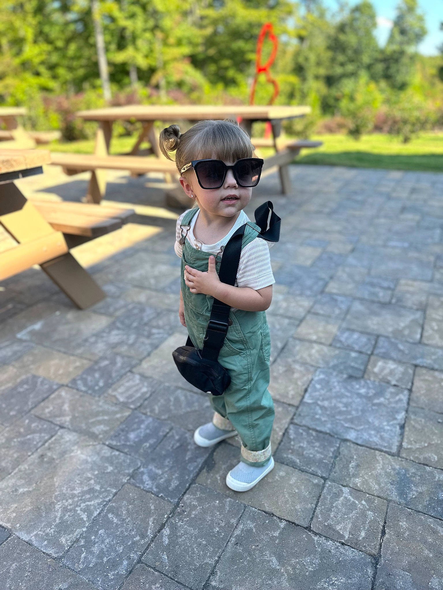 Ayla is registered to the contest to win money with this photo: baby_toddler_clothing, child, eyewear, flooring, fun, garden, grass, hat, leisure, person, personal_protective_equipment, plant, recreation, road_surface, sitting, sunglasses, toddler, tourism, travel, tree