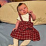 Lila joined the competition — help win amazing prizes! baby, infant, plaid_skirt, suspenders, tights, bed, pillow, bamboo, wooden_headboard, curious_expression, clothing, indoor, person, cute, young_child, portrait, resting, fabric, sleepwear, casual
