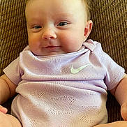 Lila joined the competition — help win amazing prizes! baby, baby_boy, baby_girl, brown_background, child, closeup, couch, cute, face, happy, indoors, infant, nike_logo, portrait, purple_clothing, sitting, skin, smile, soft_lighting, young_child