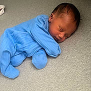 Lenox is registered to the contest to win money with this photo: newborn, baby, sleeping, blue_onesie, infant, cozy, peaceful, soft_surface, portrait, child, cute, resting, indoors, one_person, head, skin, clothing, young_child, tiny, sleep