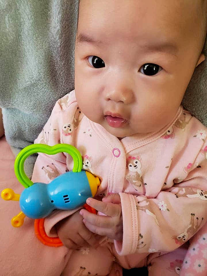 Mulan is registered to the contest to win money with this photo: baby, baby_playing_with_toys, baby_products, baby_toddler_clothing, baby_toys, cheek, child, drinkware, ear, finger, headwear, mouth, neck, nose, person, play, product, skin, toddler, toy