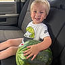 child, toddler, watermelon, car_seat, smile, blonde_hair, white_shirt, nike_logo, hand, window, seatbelt, interior, vehicle, happy, portrait, candid, summer, fruit, green, cute
