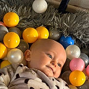 Jonathane a rejoint le concours — aidez-le/la à gagner de superbes lots ! baby, child, ball_pit, colored_balls, yellow_balls, white_balls, pink_balls, gray_balls, blue_balls, panda_onesie, plush, soft_texture, infant, face, head, cute, indoor, smile, relaxed, portrait