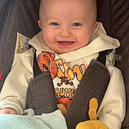 Jonathane a rejoint le concours — aidez-le/la à gagner de superbes lots ! baby, blanket, blue, car_seat, child, clothing, comfort, cute, face, happy, hoodie, indoor, infant, person, plush_toy, portrait, seatbelt, smiling, soft, yellow