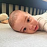 Kyson is registered to the contest to win money with this photo: baby, infant, bed, crib, teddy_bear, plush_toy, face, skin, eyes, clothing, sleepwear, lying_down, indoor, soft_lighting, child, cute, portrait, head, expression, rest