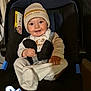 baby, car_seat, beanie, smile, clothing, child, infant, seatbelt, cute, portrait, indoors, person, happy, warm, sitting, face, headwear, toddler, small_hands, cozy