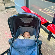 Muhammad joined the competition — help win amazing prizes! baby, stroller, infant, blue, blanket, bus_stop, bench, red, sidewalk, street, urban, outdoor, child, peaceful, waiting, transportation, pavement, canopy, daytime, casual