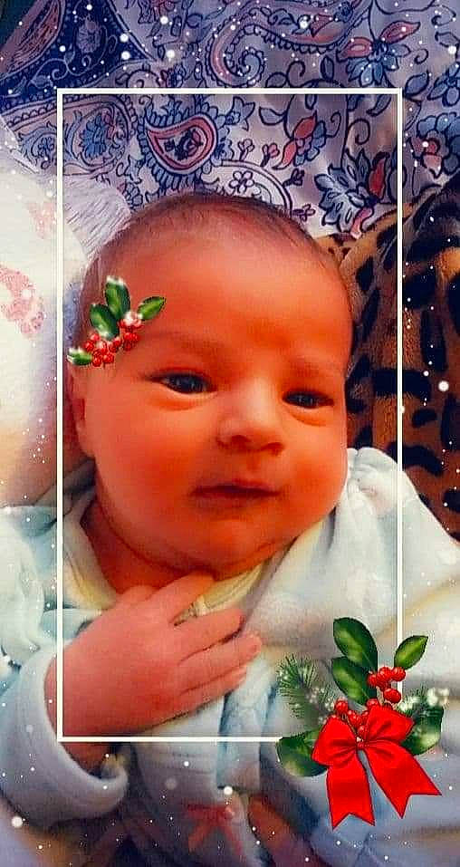 Carolyn is registered to the contest to win money with this photo: baby, cheek, child, face, facial_expression, forehead, hair_accessory, happy, head, lip, mouth, nose, person, petal, photography, photomontage, skin, smile, toddler