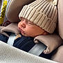 baby, sleeping, car_seat, knit_hat, beige, blanket, child, infant, cozy, cute, face, headwear, safety_harness, cushion, closeup, soft_texture, nap, indoors, person, warm