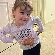 Kirin is registered to the contest to win money with this photo: child, girl, indoor, pink_bow, long_sleeve_shirt, croissant_print, leggings, socks, carpet, door, pose, smile, curly_hair, playful, young, person, cute, home, happy, portrait