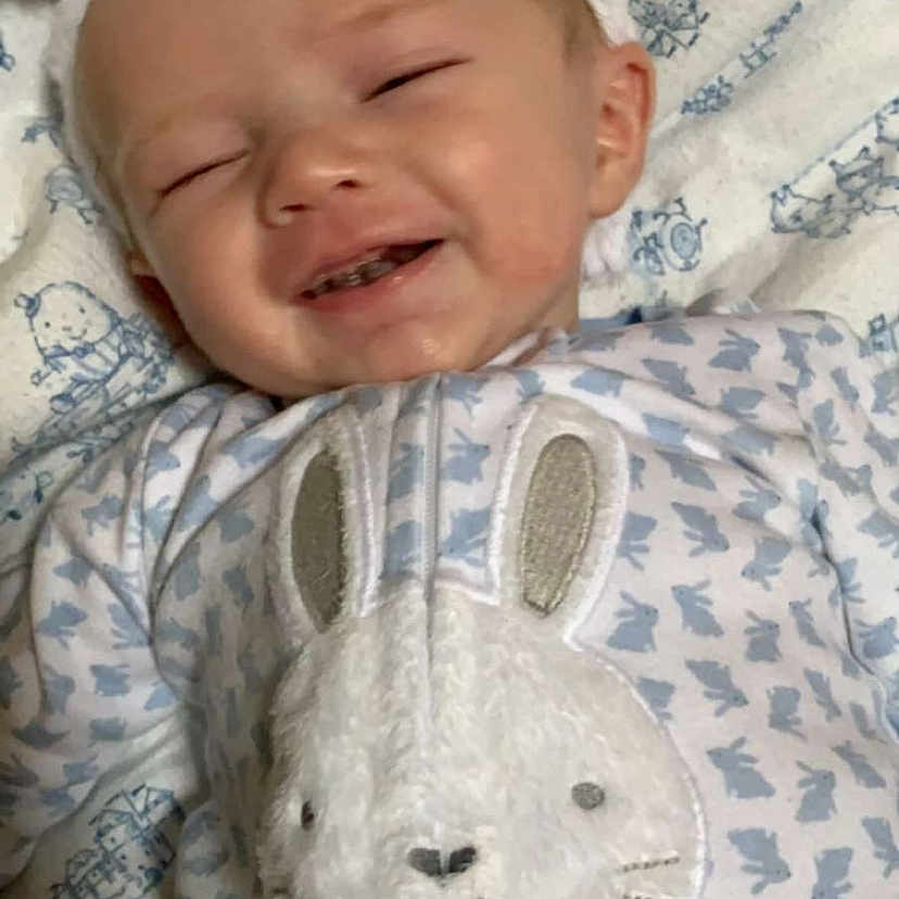 Tom is registered to the contest to win money with this photo: baby, bedtime, beige, blanket, child, domestic_rabbit, ear, head, headwear, nose, person, rabbit, skin, textile, toddler