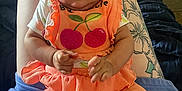 Kallie joined the competition — help win amazing prizes! baby, child, infant, orange_clothing, sitting, tattoo, person, legs, blanket, home_interior, toy, floor, cute, face, hands, casual, relaxed, indoor, people, comfort
