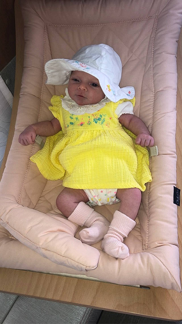 Masha participe au concours pour gagner de l'argent avec cette photo : baby, baby_toddler_clothing, cap, chair, comfort, face, finger, hand, hat, headgear, headwear, lap, person, pink, product, skin, sleeve, sun_hat, textile, thigh