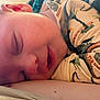 animal_print, baby, blanket, child, closeup, comfort, cozy, cute, ears, face, head, indoors, mouth, pajamas, peaceful, portrait, resting, skin, sleeping, soft_lighting