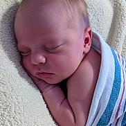 Heath is registered to the contest to win money with this photo: baby, blanket, child, closeup, cozy, ear, face, hand, head, indoors, infant, newborn, peaceful, portrait, resting, skin, sleeping, soft_texture, striped_blanket, wrapped