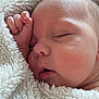 baby, infant, newborn, sleeping, blanket, cozy, close_up, face, cheek, hand, fingers, thumb, peaceful, plush_blanket, soft_texture, skin, portrait, mouth, eyelids, bedding