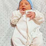 Assrar a rejoint le concours — aidez-le/la à gagner de superbes lots ! newborn, baby, infant, white_onesie, blue_hat, blanket, sleeping, soft_texture, closeup, cute, peaceful, small_hands, lying_down, indoors, portrait, baby_clothing, child, resting, cozy, infant_baby