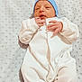 newborn, baby, infant, white_onesie, blue_hat, blanket, sleeping, soft_texture, closeup, cute, peaceful, small_hands, lying_down, indoors, portrait, baby_clothing, child, resting, cozy, infant_baby
