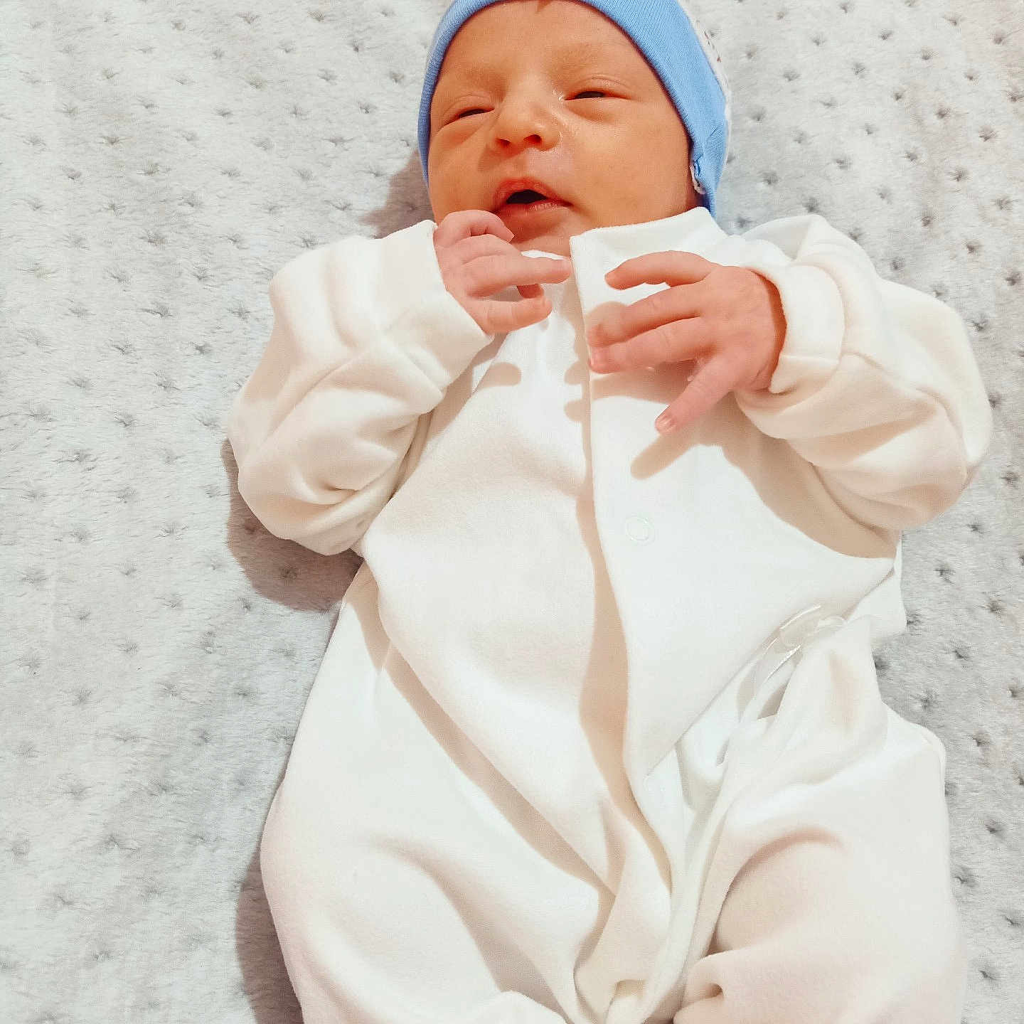 Assrar a rejoint le concours — aidez-le/la à gagner de superbes lots ! baby, baby_clothing, blanket, blue_hat, child, closeup, cozy, cute, indoors, infant, infant_baby, lying_down, newborn, peaceful, portrait, resting, sleeping, small_hands, soft_texture, white_onesie