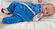 Gabriel participe au concours pour gagner de l'argent avec cette photo : baby, infant, blue_overalls, mickey_mouse, socks, lying_down, white_towel, cute, child, newborn, portrait, soft_texture, clothing, hand, face, eyes, head, small, resting, indoor