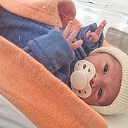 Gabriel participe au concours pour gagner de l'argent avec cette photo : newborn, baby, pacifier, hospital, bassinet, blanket, knit_hat, clothing, bed, infant, person, sleepwear, cute, small_hands, wrapped, resting, indoors, medical_setting, portrait, human