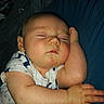 Preston Kjeldgard is registered to the contest to win money with this photo: newborn, baby, infant, sleeping, sleepy, portrait, face, closed_eyes, resting, arm, hand, onesie, clothing, blue_fabric, indoor, close_up, peaceful, cute, photograph, nap