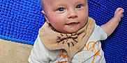Leo joined the competition — help win amazing prizes! baby, child, infant, blue_rug, wooden_floor, bib, white_shirt, orange_pants, cute, smiling, face, eyes, lying_down, indoor, playful, clothing, flooring, person, portrait, toddler