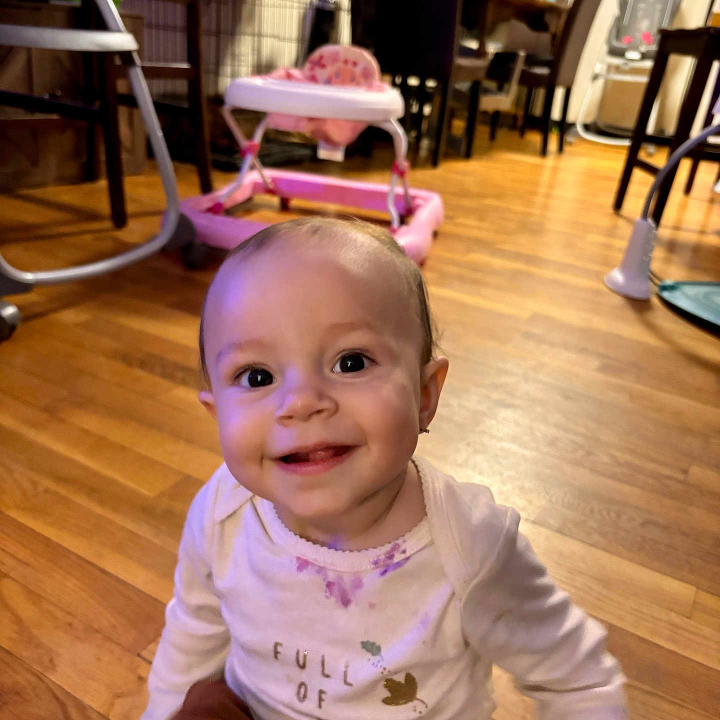 Amelia joined the competition — help win amazing prizes! baby, child, clothing, cute, face, floor, furniture, happy, high_chair, home, indoor, infant, person, playtime, room, sitting, smiling, walker, wooden_floor, young_child
