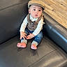 baby, child, infant, portrait, sitting, couch, leather, hat, newsboy_cap, vest, bow_tie, shirt, jeans, bare_feet, indoors, living_room, wood_floor, furniture, looking_at_camera, cute