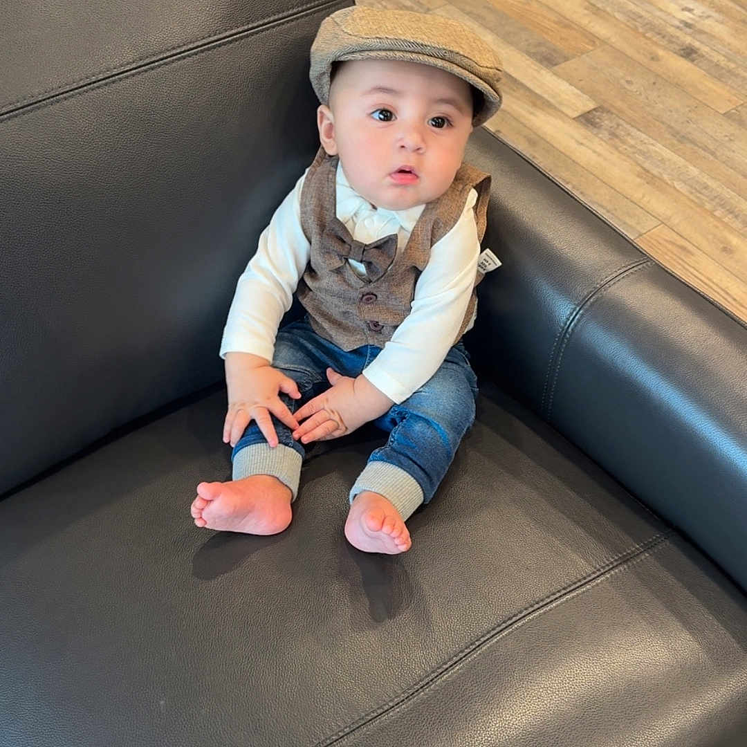 Ayden joined the competition — help win amazing prizes! baby, child, infant, portrait, sitting, couch, leather, hat, newsboy_cap, vest, bow_tie, shirt, jeans, bare_feet, indoors, living_room, wood_floor, furniture, looking_at_camera, cute