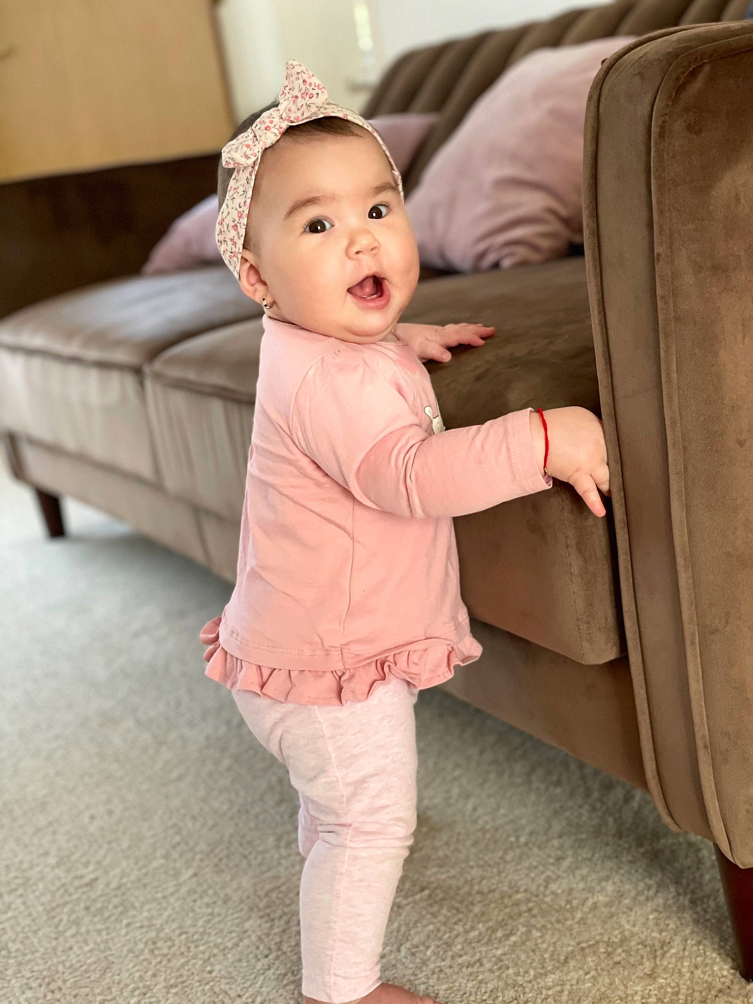 Lara joined the competition — help win amazing prizes! baby, baby_toddler_clothing, cheek, child, comfort, couch, face, floor, flooring, fun, fur, hardwood, human_leg, joint, person, sitting, sleeve, smile, standing, toddler