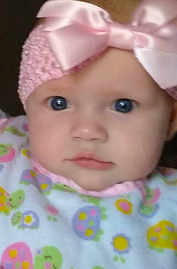 Beatrice is registered to the contest to win money with this photo: baby, cheek, child, eye, face, forehead, hair_accessory, head, headgear, lip, mouth, nose, person, pink, skin, toddler