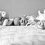 baby, plush_toy, bunny, blanket, infant, soft_toy, monochrome, portrait, child, sleepwear, cute, lying_down, peaceful, close_up, indoor, toy, face, hand, cozy, comfort