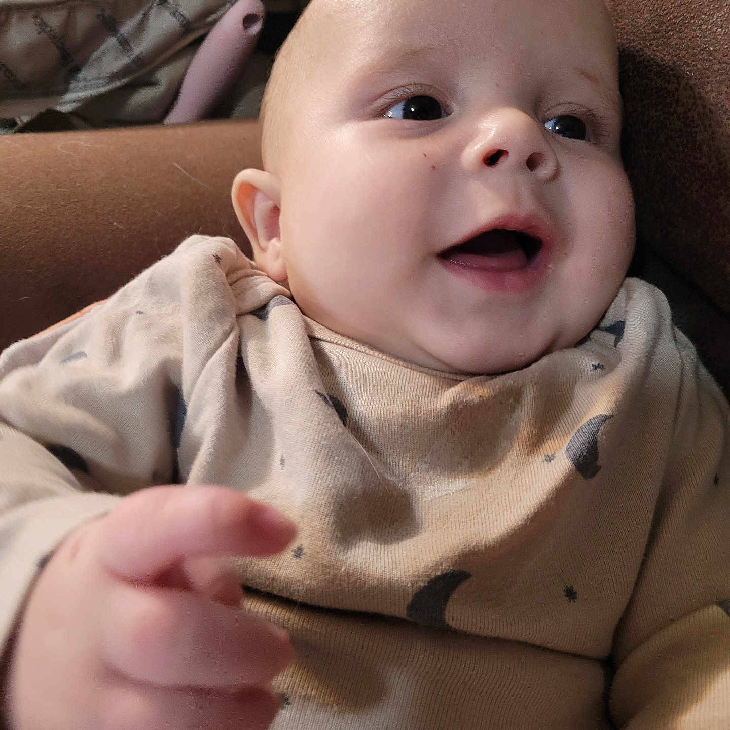 Marcell is registered to the contest to win money with this photo: baby, infant, smile, face, hand, clothing, moon_pattern, stars_pattern, cozy, couch, indoor, person, skin, happiness, portrait, cute, child, closeup, expression, warm
