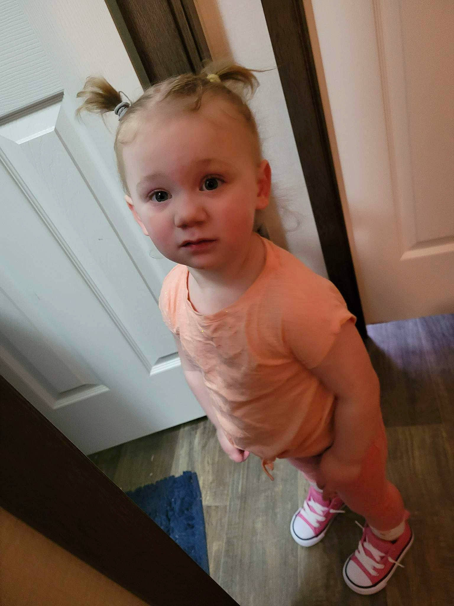 Ariel is registered to the contest to win money with this photo: baby, baby_toddler_clothing, blond, cheek, chest, child, door, elbow, eyelash, flooring, fun, happy, hardwood, human_leg, person, skin, sleeve, standing, toddler, trunk