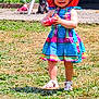 building, child, dog, dress, footwear, grass, happy, hat, nature, outdoor, person, pink_hat, plant, sandals, smiling, sunny, toddler, toy, white_chair, window