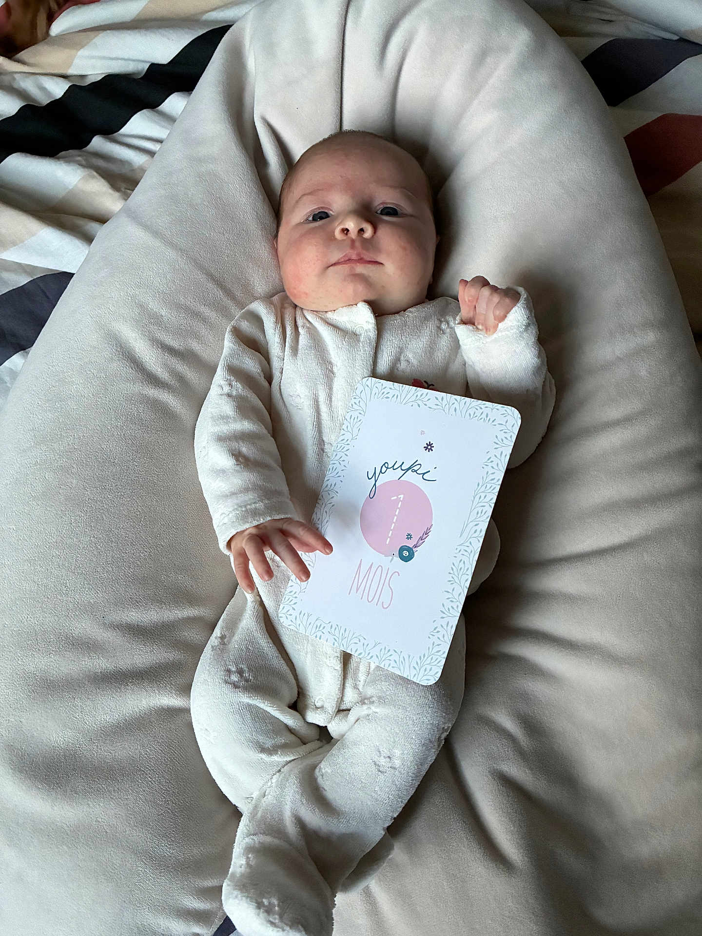 Giulyana participe au concours pour gagner de l'argent avec cette photo : baby, infant, onesie, milestone_card, cushion, soft_fabric, lying_down, indoor, portrait, face, hand, footed_pajamas, newborn, cute, child, sleepwear, baby_clothes, expression, skin, comfort