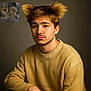young_man, portrait, dog_ears_hair, fluffy_hair, beige_sweater, indoor, studio_lighting, small_dog, fluffy_dog, dog, digital_edit, humor, comparison, brown_hair, facial_hair, neutral_expression, closeup, seated, background, inset_photo