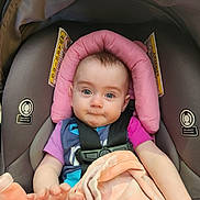 Ariana joined the competition — help win amazing prizes! baby, car_seat, seatbelt, pink_headrest, blanket, drool, infant, child, blue_eyes, clothing, soft_toy, sitting, cute, portrait, indoor, safety, child_seat, expression, hands, closeup