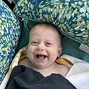 Rylan is registered to the contest to win money with this photo: baby, smiling, towel, blanket, cushion, patterned, happy, child, face, portrait, indoors, closeup, head, skin, expression, comfort, seat, infant, cheerful, young