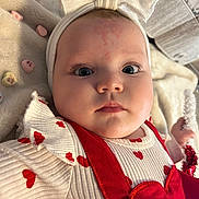 Aspyn is registered to the contest to win money with this photo: baby, infant, headband, bow, blanket, valentine_candy, heart_pattern, red_outfit, close_up, portrait, big_eyes, cheeks, lying_down, soft_texture, newspaper, plush, hand, skin_mark, curious_gaze, cute_expression