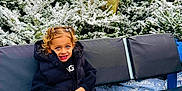 Aria a rejoint le concours — aidez-le/la à gagner de superbes lots ! child, blue_eyes, pigtails, black_jacket, leggings, boots, bench, snow, pine_trees, frost, deer_statue, antlers, winter, outdoor, smiling, curly_hair, holiday_decor, playful, park, daytime