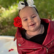 Aila participe au concours pour gagner de l'argent avec cette photo : baby, child, face, smile, red_jacket, flower, headband, outdoor, greenery, portrait, cute, happy, infant, fashion, closeup, baby_clothing, head_accessory, nature, soft_light, sitting