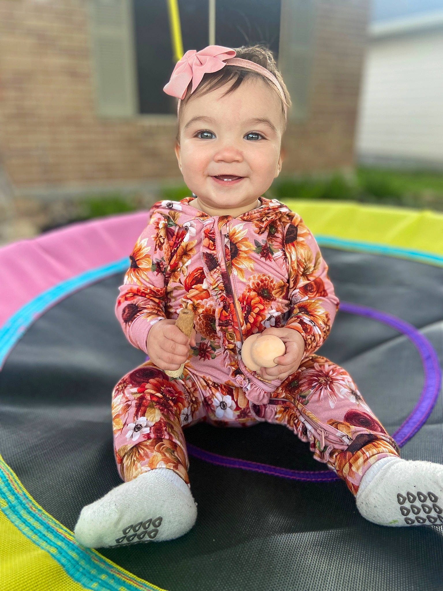 Sadie is registered to the contest to win money with this photo: baby, baby_toddler_clothing, child, event, face, facial_expression, fashion_accessory, fun, grass, green, happy, joy, magenta, pattern, person, pink, purple, recreation, sitting, sleeve