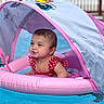 baby, child, swimming_pool, inflatable, float, pink, water, swimsuit, sunshade, people, outdoor, summer, fun, happy, cute, sitting, portrait, pool, leisure, relaxation