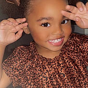 Miamor is registered to the contest to win money with this photo: child, girl, smiling, curly_hair, bows, leopard_print, dress, happy, portrait, playful, hands, face, teeth, cute, indoor, person, fashion, hair_accessory, joyful, young