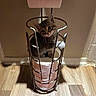 kitten, cat, toilet_paper, toilet_paper_holder, floor, wood_floor, wall, metal, pet, indoor, cute, small, playful, curious, animal, feline, domestic_animal, paws, sitting, shadow