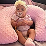 Ameliana is registered to the contest to win money with this photo: baby, bed, child, clothing, cushion, cute, cute_expression, flower, hands, headband, indoors, infant, pacifier, person, pillow, pink, portrait, sitting, socks, soft_texture